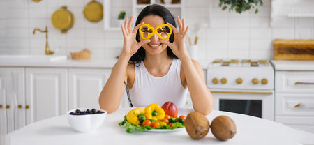 A woman holding vegetables in hand for eye care to help improve vision and help maintain the eye health with nourishing foods