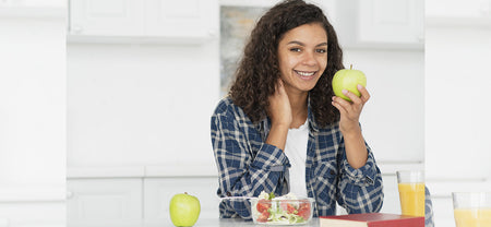 Woman having an apple to help boost female metabolism and support women nutrition for healthy ageing
