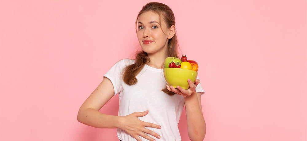 A girl holding a food bowl to maintain a healthy and balanced diet to support smooth digestion and help improve gut health
