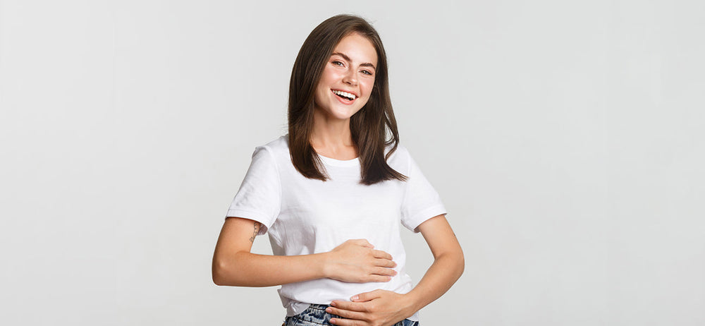 Happy woman holds her belly after getting gut problems and indigestion relief 
