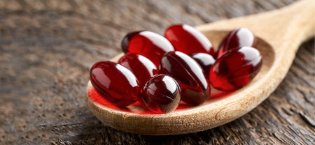 A spoon containg Krill oil Capsules which will help you in supporting your Liver and Heart Health